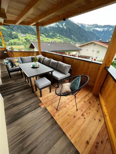a balcony with a couch and a table and chairs at Landhaus Daum in Schwendau