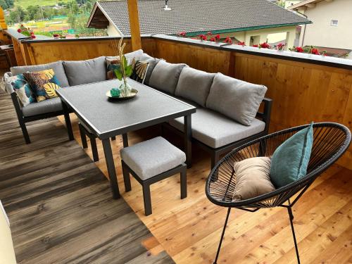 a patio with a couch and a table and chairs at Landhaus Daum in Schwendau