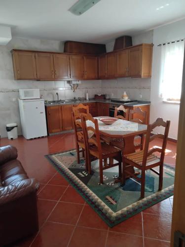 a kitchen with a table and chairs in a room at Casa do Campo in Seia