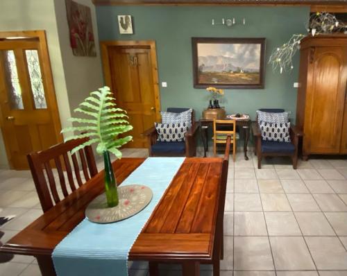 a dining room with a table with a plant on it at Olive Leaves Guest House in Gaborone
