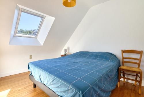 a bedroom with a bed and a chair and a window at L'Odyssée in Saint-Nic