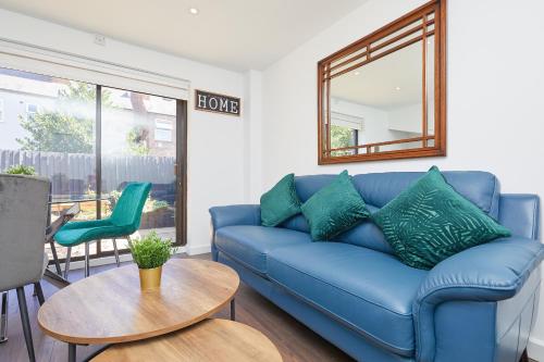 a living room with a blue couch and a table at Modern 2 Bed House by City Centre in Nottingham
