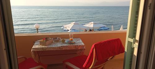 a view of the ocean from a balcony with a table and chairs at Beatrice's apartment in Acharavi