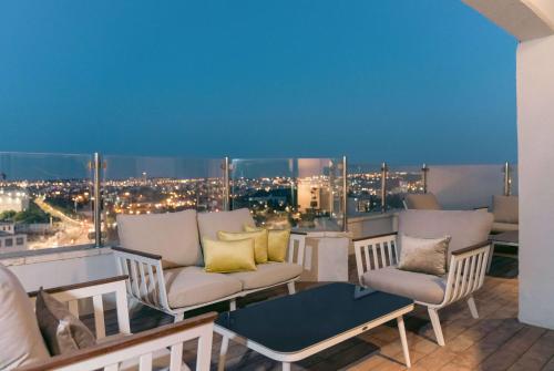 a balcony with couches and a view of a city at Ramada Jerusalem Hotel in Jerusalem