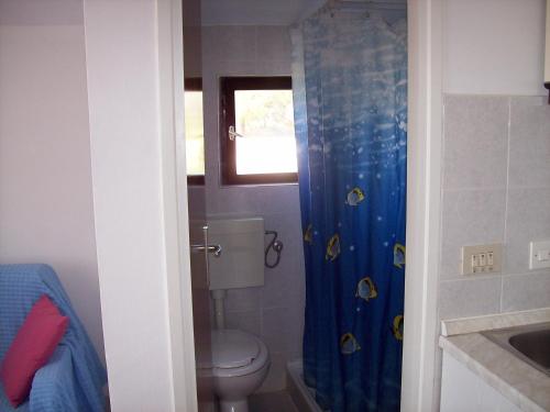 łazienka z toaletą i niebieską zasłoną prysznicową w obiekcie Apartments by the sea Sevid, Trogir - 11505 w mieście Sevid