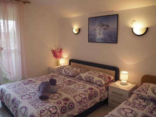 sypialnia z 2 łóżkami i zdjęciem na ścianie w obiekcie Apartments by the sea Sevid, Trogir - 11505 w mieście Sevid