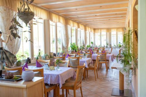 um restaurante com mesas, cadeiras e janelas em Perle am Rhein em Boppard