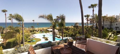 a view of a resort with a swimming pool and the ocean at Espectacular apartamento primera linea de playa - Golf in Estepona