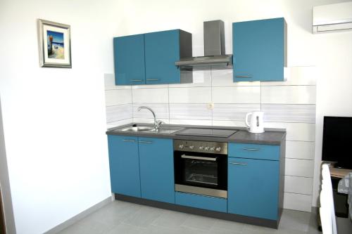 una cucina con armadi blu e lavandino di Apartments with a parking space Marina, Trogir - 11607 a Marina