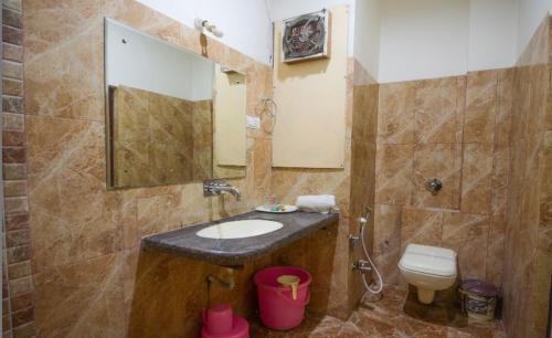 a bathroom with a sink and a toilet and a mirror at Hotel Vishnu Vilas in Rewa