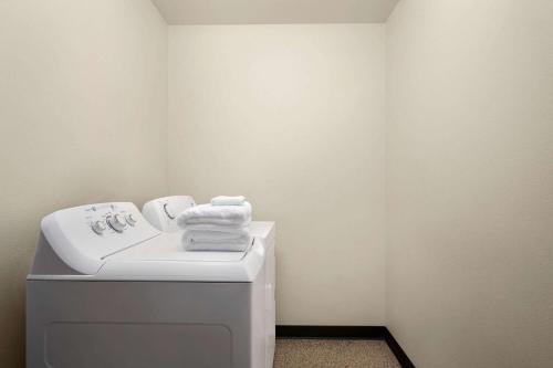ein Badezimmer mit einem Waschbecken und einer Waschmaschine in der Unterkunft Baymont by Wyndham Fremont in Fremont