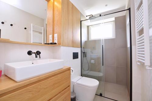 ein Bad mit einem Waschbecken, einem WC und einer Dusche in der Unterkunft Victus Apartamenty, Apartament Boho in Sopot