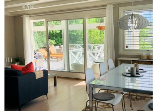 a dining room and living room with a table and chairs at Renovated sea facing cottage on the Eidanger fjord in Porsgrunn