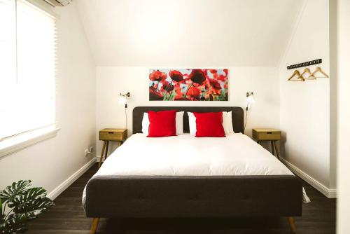una camera da letto con un letto grande con cuscini rossi di The Loft @ Denver a East Maitland