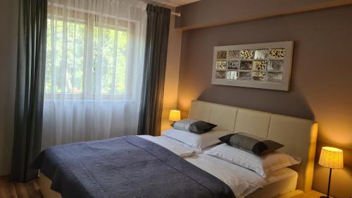 a bedroom with a bed with two pillows and a window at Villa Amalia Apartments in Malinska