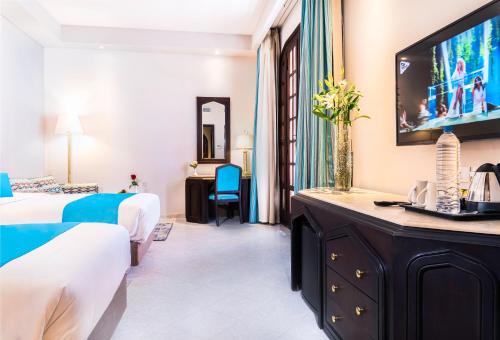 a hotel room with two beds and a flat screen tv at Safir Dahab Resort in Dahab