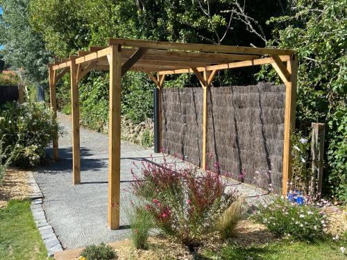a wooden pergola in the middle of a garden at L Her Beau d Hier in LʼÉpine