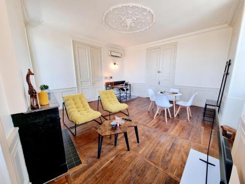 uma sala de estar com cadeiras amarelas e uma mesa em Superbe T2 lumineux avec fibre em Angoulême