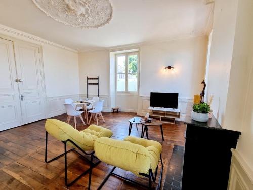 uma sala de estar com cadeiras amarelas e uma televisão em Superbe T2 lumineux avec fibre em Angoulême