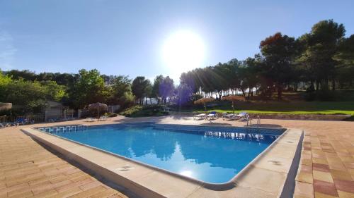 uma grande piscina azul com cadeiras e árvores em Finca La Celada em Moratalla