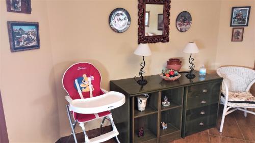 a room with a high chair and a dresser at Villa privada para familias in Torrox