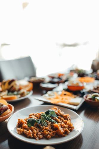 a wooden table with plates of food on it at Zara Cave Hotel in Goreme