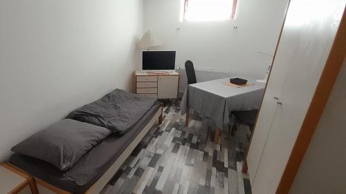 a small bedroom with a bed and a desk with a computer at Gästezimmer Salzgitter II in Wolfenbüttel in Wolfenbüttel