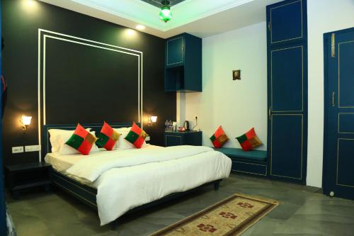 a bedroom with a large bed with red pillows at Shiv Kothi - Homestay in Agra
