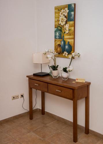 a table with two vases and a lamp on it at Casas Campo Cimo da Quinta in Miranda do Douro