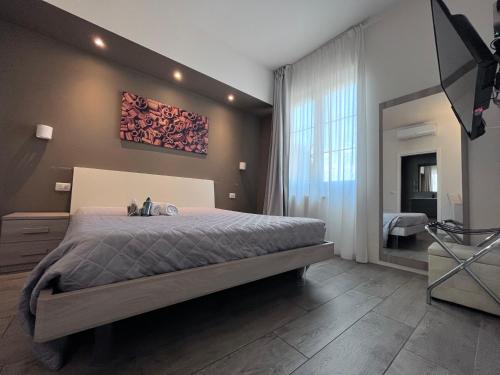 ein Schlafzimmer mit einem großen Bett und einem großen Fenster in der Unterkunft VILLA FENIX OSIO SOTTO 2 in Osio Sotto