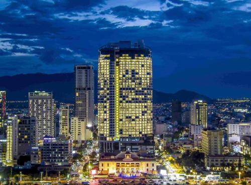 a city skyline at night with a tall building at Panorama Nha Trang Inn in Nha Trang