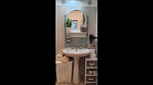 a bathroom with a sink and a mirror at Appartamento - Villaggio Terrata- Golfo Aranci in Marinella