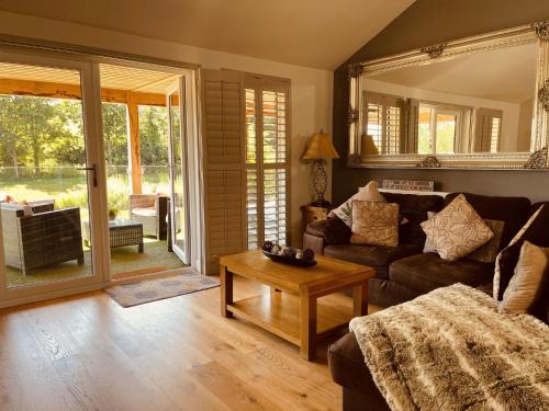 a living room with a couch and a table at Oak Lodge, South View Lodges, Exeter in Exeter