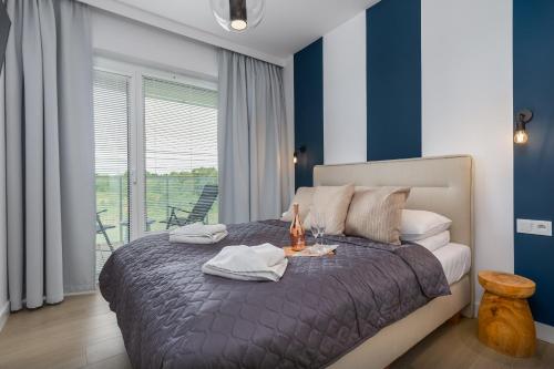 a bedroom with a bed with blue and white stripes at Apartamenty Polanki Aqua BASENY & SPA Kołobrzeg by Renters Prestige in Kołobrzeg