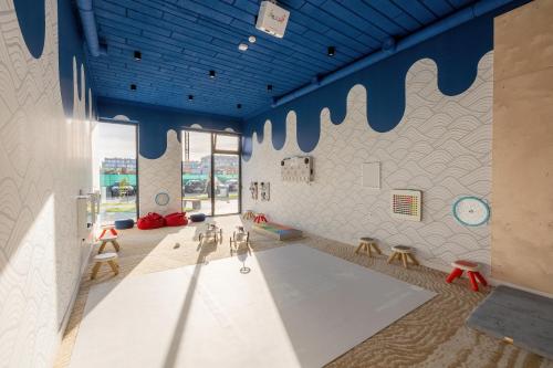 una stanza con sedie e una parete con soffitti blu di Apartment Polanki Aqua Kołobrzeg by Renters Prestige a Kołobrzeg