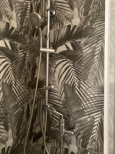 a shower in a bathroom with a leafy wall at PALAZZO PORCARI in Lecce
