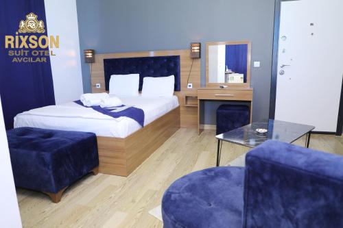 a bedroom with a bed and two blue chairs at Rixson Otel in Avcılar