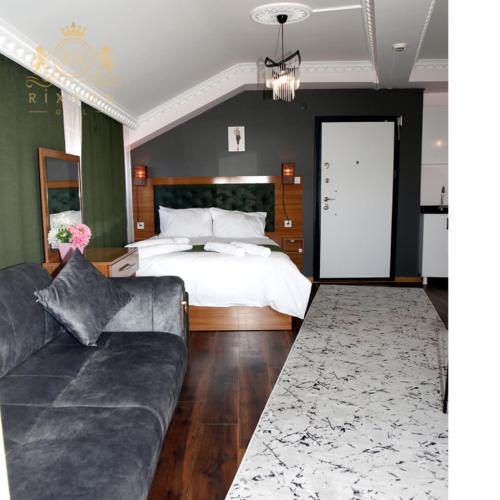 a bedroom with a bed and a couch and a bed at Rixson Otel in Avcılar