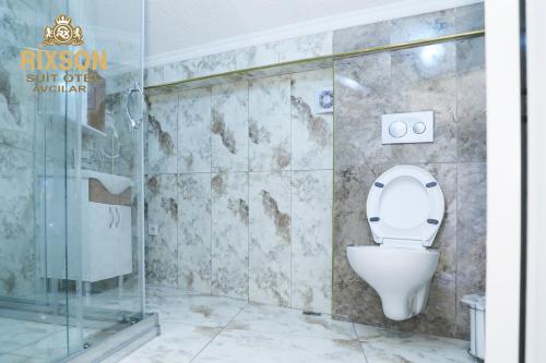 uma casa de banho com um WC e uma cabina de duche em vidro. em Rixson Otel em Avcılar