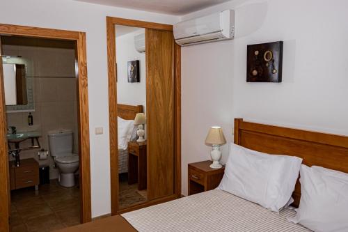 a bedroom with a bed and a bathroom with a sink at Casas Campo Cimo da Quinta in Miranda do Douro