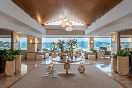 eine große Lobby mit einem Tisch mit Gläsern und Blumen in der Unterkunft Iberostar Selection Jardín del Sol Suites - Adults Only in Santa Ponsa
