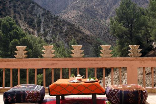 a table on a balcony with a view of a mountain at Atlas Tigmi in Ourika