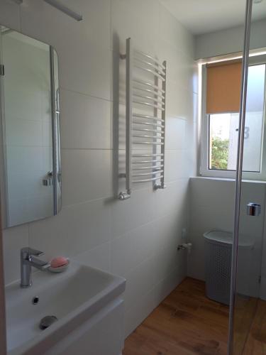 a white bathroom with a sink and a mirror at Piotruś Pan by Orzechowa Przystań Centrum przy promenadzie in Ustka