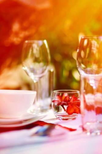a table with two wine glasses and a bowl of fruit at Eureka Villas Siem Reap in Siem Reap