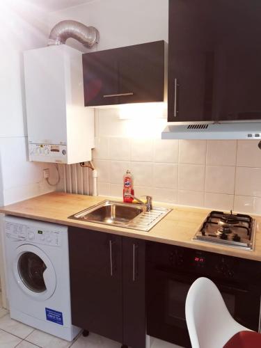 a kitchen with a sink and a washing machine at Appart T1bis Malbosc in Montpellier