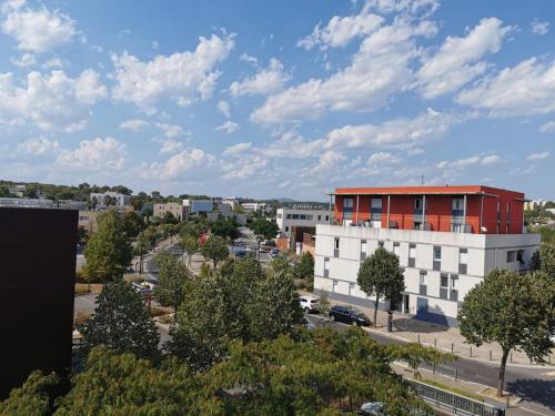 eine Luftansicht einer Stadt mit einem roten Gebäude in der Unterkunft Appart T1bis Malbosc in Montpellier