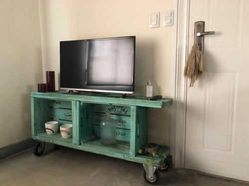 a tv on a cart with a television on it at Calm in Carmelo