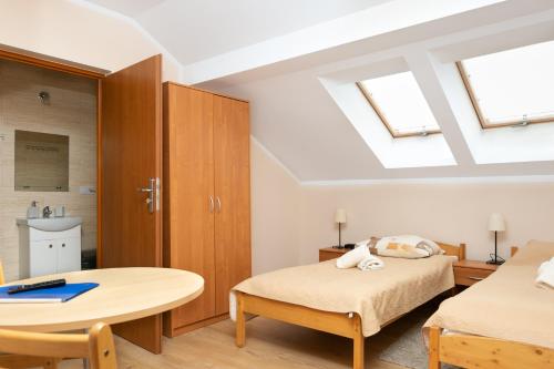 a bedroom with two beds and a table at MADOHORA_SŁOŃCE in Zaryte