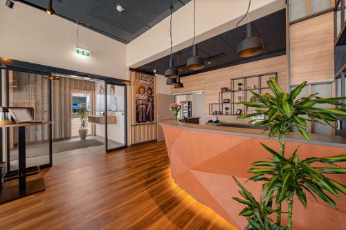 an office lobby with a reception counter and plants at Zündwerk - Motel in Strasshof an der Nordbahn