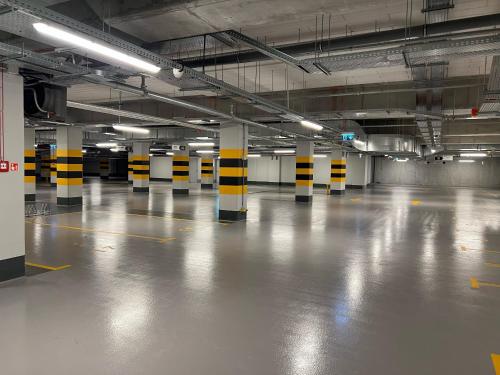 an empty parking garage with yellow and black poles in it at ibis Styles Kraków Centrum in Kraków